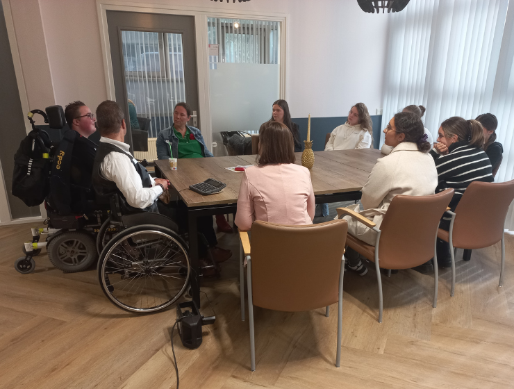 Studenten aan tafel met cliënten voor de VGZ-dag